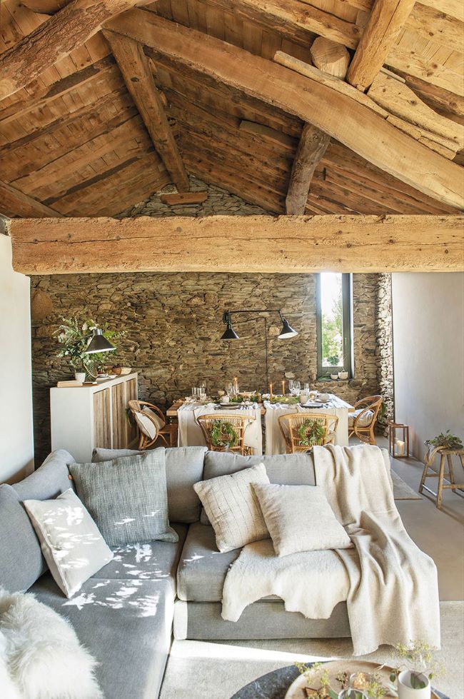 Rustykalny salon z elementami drewna, kamienia i lnu; źródło: https://www.elmueble.com/